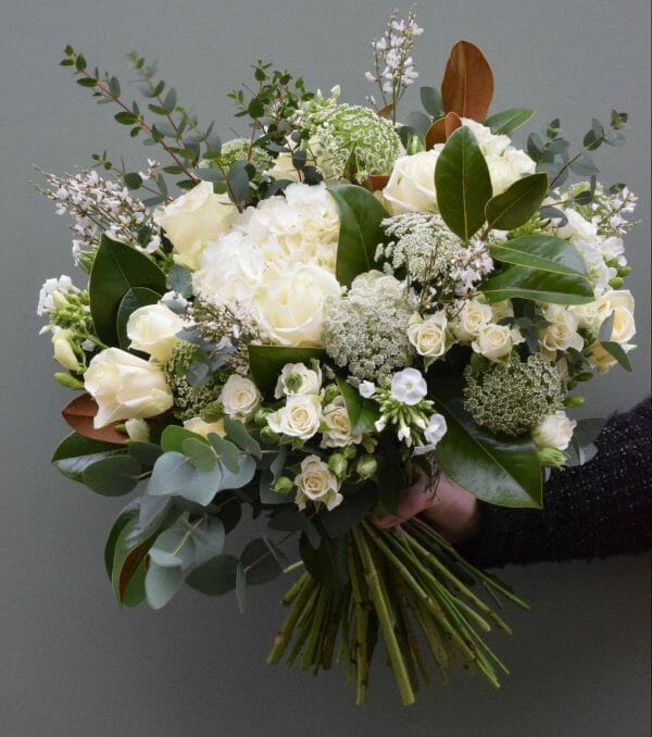 Photo showing a sample of a white and cream seasonal hand tied bouquet available to order from Kensington Flowers London