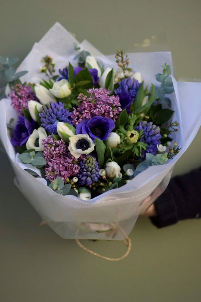 Photo showing a white and purple/blue Spring Bouquet available to order from Kensington flowers, London