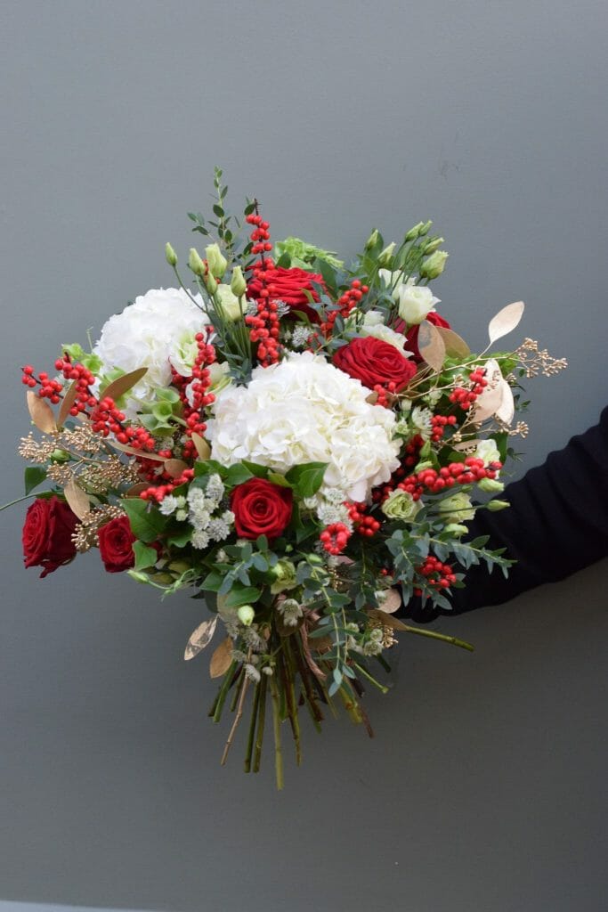 Christmas bouquet of seasonal reds, greens and whites available from Kensington Flowers London