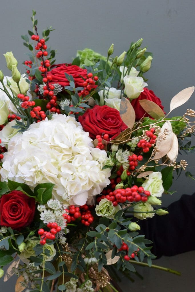 Christmas bouquet of seasonal reds, greens and whites available from Kensington Flowers London