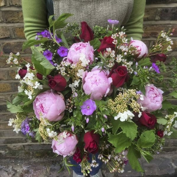 Photo showing a sample of a large florist choice summer bouquet pinks and red,Peonies, scented red roses and phlox from Kensington flowers