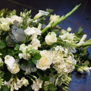 Photo of a funeral spray arrangement of all white flowers funeral flowers from Kensington flowers.