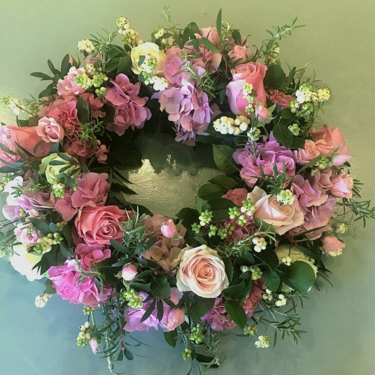 Photo of a pink and white Funeral flowers wreath tribute available to order from Kensington flowers London