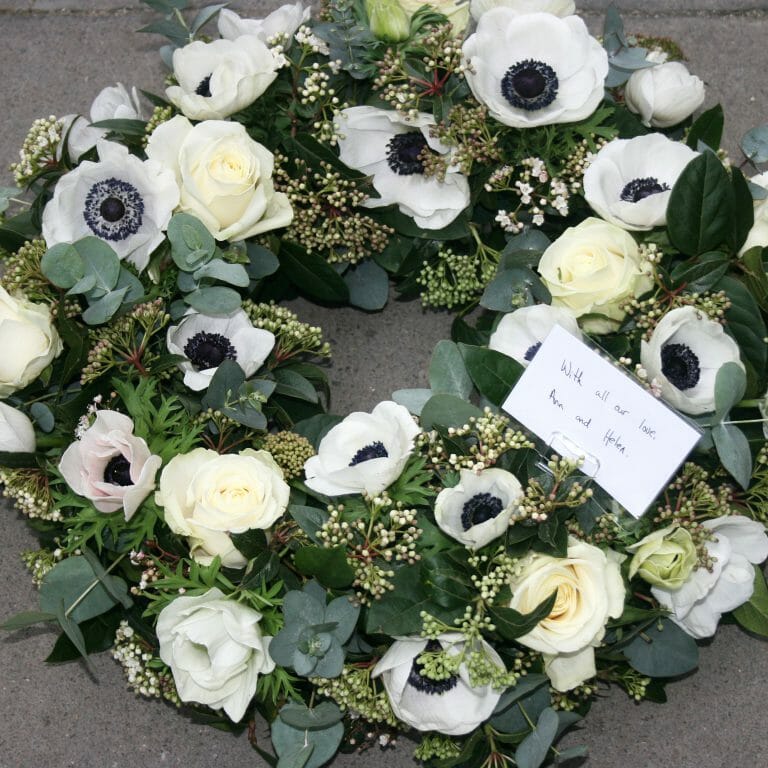 Photo showing a sample of a White funeral wreath tribute available at Kensington flowers London