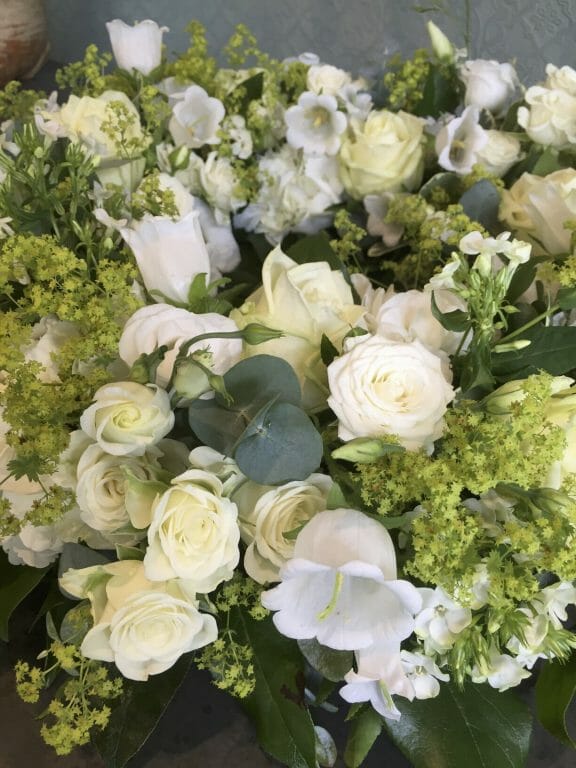Photo showing a close up image of a white floral arrangement roses Kensington flowers