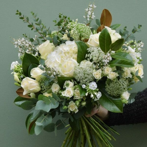 Photo showing a sample of a white and cream seasonal hand tied bouquet available to order from Kensington Flowers London