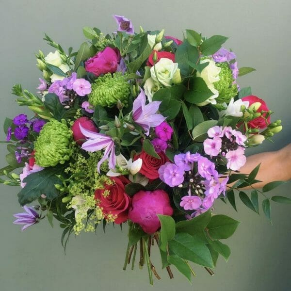 Photo showing a sample of a Seasonal hand tied bouquet vivid and mixed colours Kensington flowers London