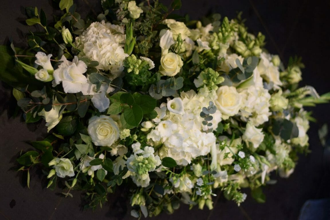 Photo of a funeral spray arrangement of all white flowers funeral flowers from Kensington flowers.