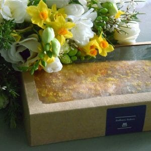 Photo showing a sample of a gift set of Flowers and lemon drizzle cake available to order at Kensington flowers London