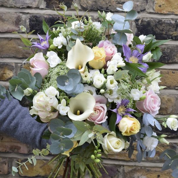 Photo of a Seasonal Rose Bouquets in pastel colours roses, freesia, calls lily, clematis included in sample from Kensington flowers London