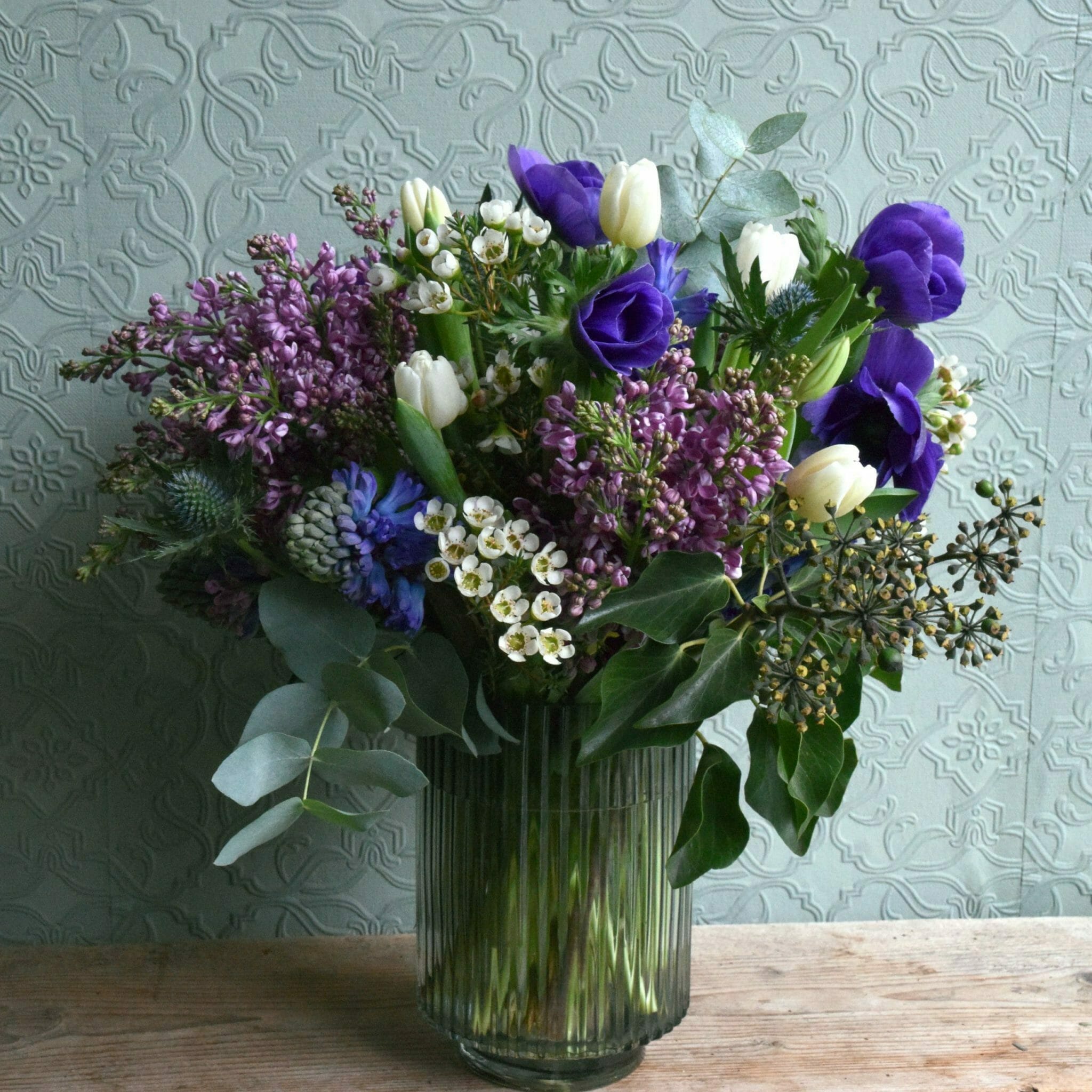 Photo showing a sample of a seasonal spring vase arrangement in blues, lilacs or white available to order from Kensington flowers London