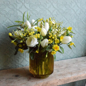 Photo showing a sample of a Spring flower vase arrangement in yellow and whites available to order from Kensington flowers London