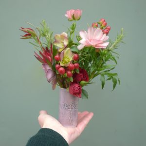 Photo showing a sample of the stoneware clay glazed botanical vase of flowers, available to order from Kensington Flowers London